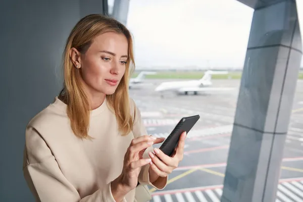 彼女の携帯電話を屋内で使用して集中白人の若い旅行者 — ストック写真