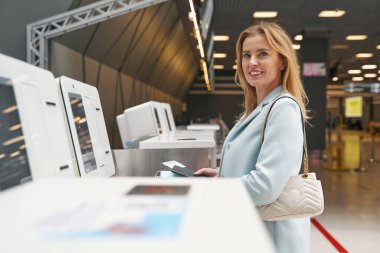 Otomatik servis çantasındaki kameraya poz veren mutlu yolcu