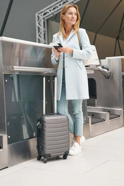 Pasażerka stojąca przy zrzucie torby samoobsługowej — Zdjęcie stockowe