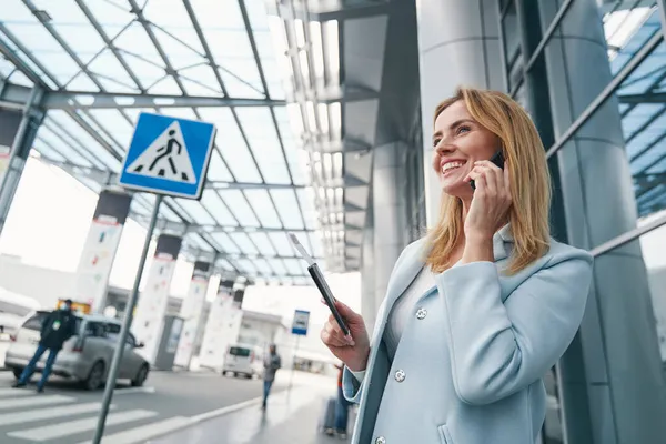 Passagier met instapkaart die buiten op smartphone praat — Stockfoto