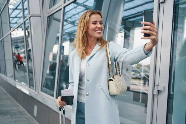 Радостная пассажирка фотографирует себя со смартфоном — стоковое фото