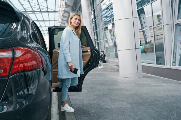 Donna allegra con documento di viaggio che lascia il taxi — Foto Stock