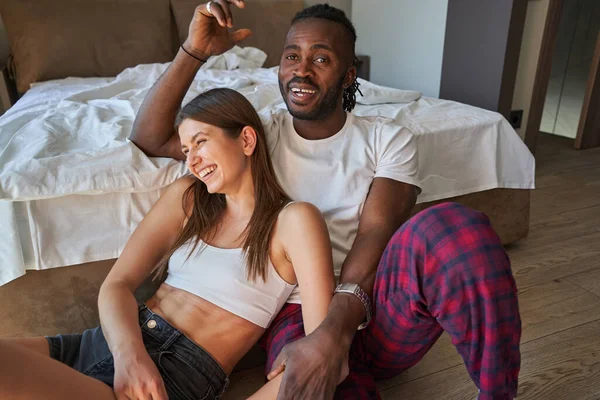 Радостная женщина и счастливый парень сидят в спальне — стоковое фото