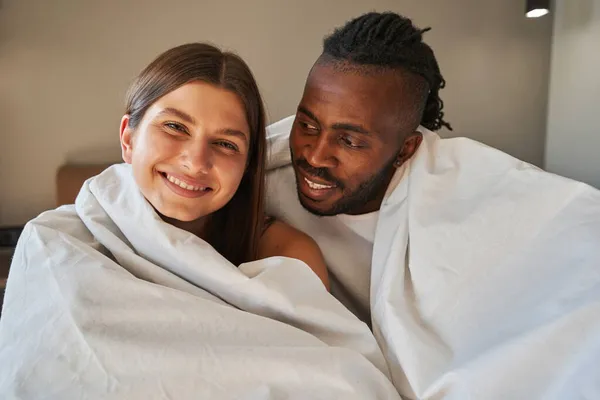 Happy woman and romantic man seated in bed — Stock Photo, Image
