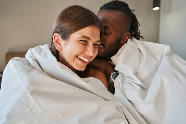 Affectionate guy talking to joyous lady in bed — Stock Photo, Image