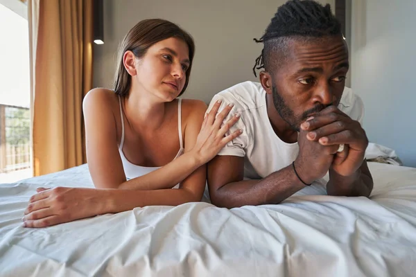 Upset guy disregarding woman lying beside him — Stock Photo, Image