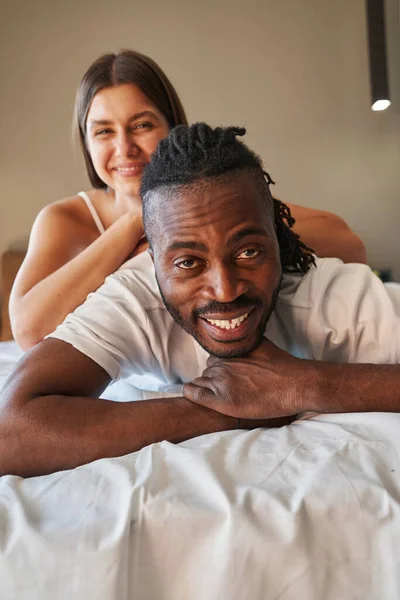 Alegre joven pareja posando para cámara en cama —  Fotos de Stock