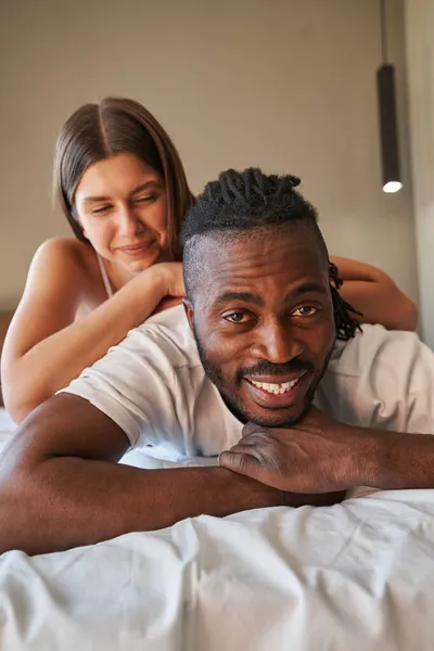 Happy romantic mixed-race couple lying in bed — Stock Photo, Image