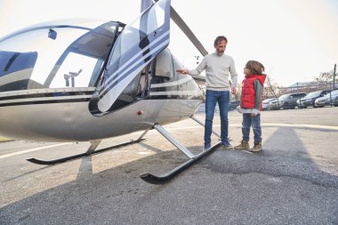 İlgili bir ebeveyn çocuğunu helikopter gezisine götürüyor.