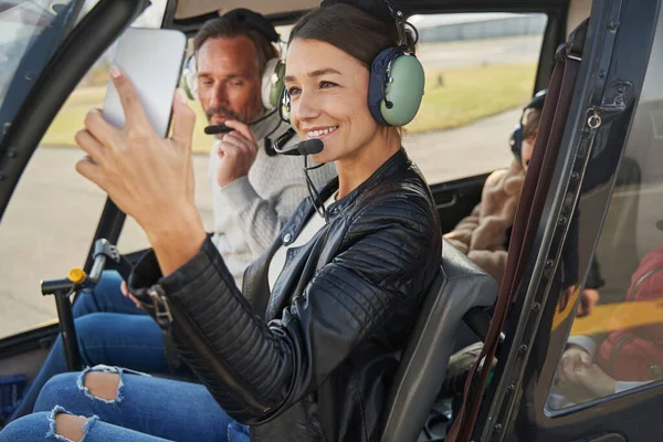 Feliz dama haciendo recuerdos con su familia en vuelo en helicóptero —  Fotos de Stock