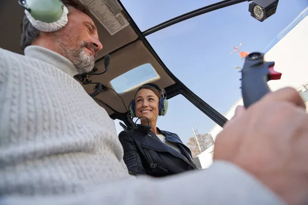 Mujer encantadora y su hombre disfrutando de un vuelo en helicóptero juntos — Foto de Stock