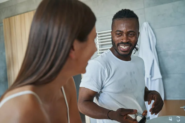 Χαρούμενος άντρας χαμογελάει στη γυναίκα πριν τη διαδικασία ξυρίσματος. — Φωτογραφία Αρχείου