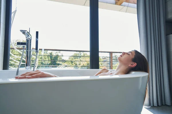 Femme sereine avec les yeux fermés couché dans le bain — Photo