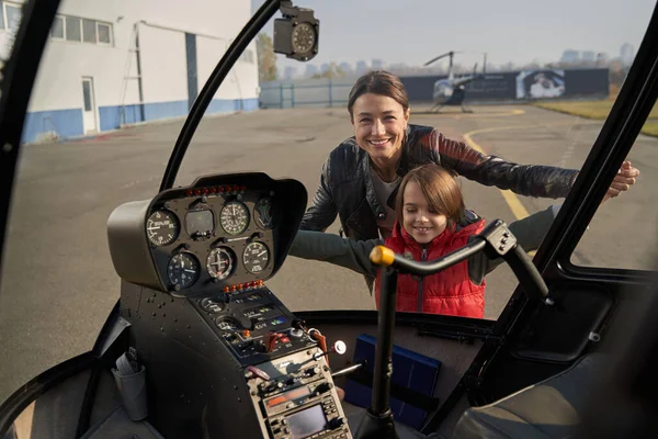 Sorridente jovem senhora se divertindo com seu filho perto de avião — Fotografia de Stock