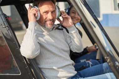 Neşeli helikopter pilotu bayanı uçuşa götürüyor.