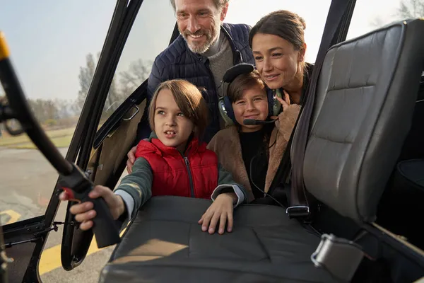 Curious children and their parents exploring in the helicopter — Stock Photo, Image