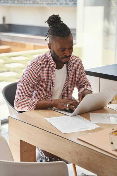 Joven enfocado trabajando en su portátil — Foto de Stock