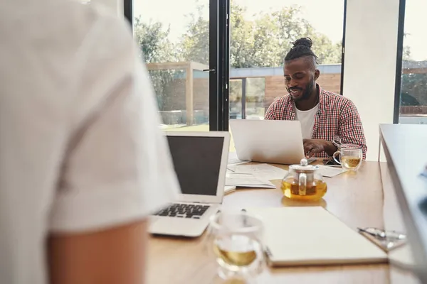 El teletrabajo enfocado está escribiendo en su computadora portátil —  Fotos de Stock