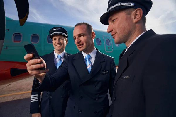 Tre piloter tar en bild av sig själva på smartphone — Stockfoto