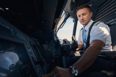 İkinci pilot kokpitteki koltuğundan düğmeye basıyor.