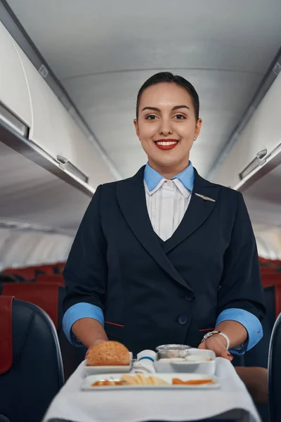 Uvítací letuška tlačí jídlo vozík uvnitř letadla — Stock fotografie