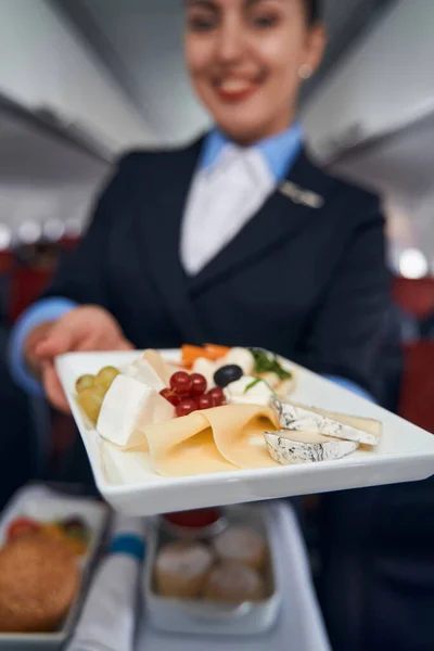 Flight attendant handing out plate with breakfast — Stock Photo, Image