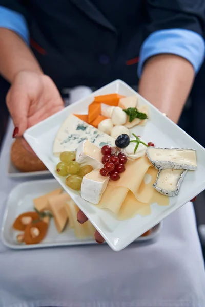 Cabin crew member showing food to camera