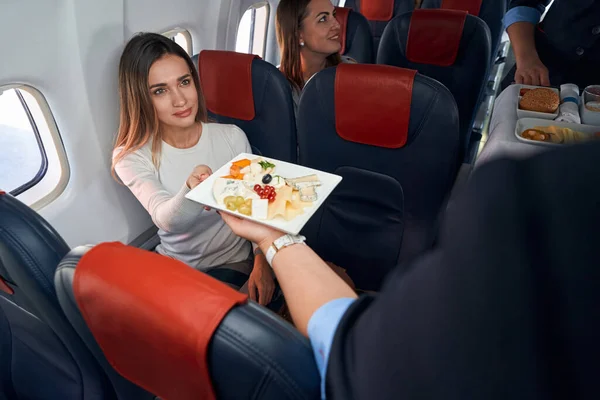 Female receiving airline meal from flight attendant — Stock Photo, Image