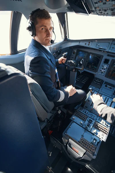 Flygkaptenen vänder sig till kameran från sittplatsen i cockpit — Stockfoto