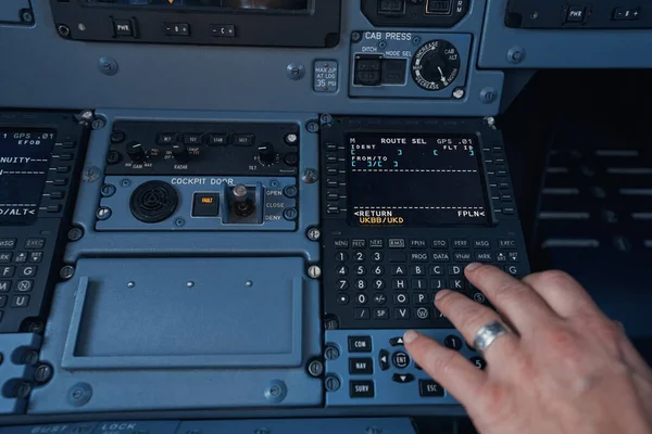 Pilot wprowadzający informacje o locie do systemu samolotu — Zdjęcie stockowe