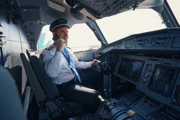 Capitán de avión hablando por teléfono en cabina — Foto de Stock