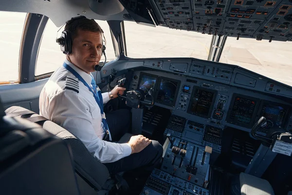 Flygplanspiloten tittar bakåt från sittplatsen i cockpit — Stockfoto