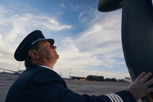 Capitán de avión maduro tocando la superficie del avión — Foto de Stock