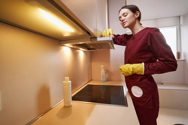 Уборщик вытирает кухонное устройство микроволоконной тканью — стоковое фото