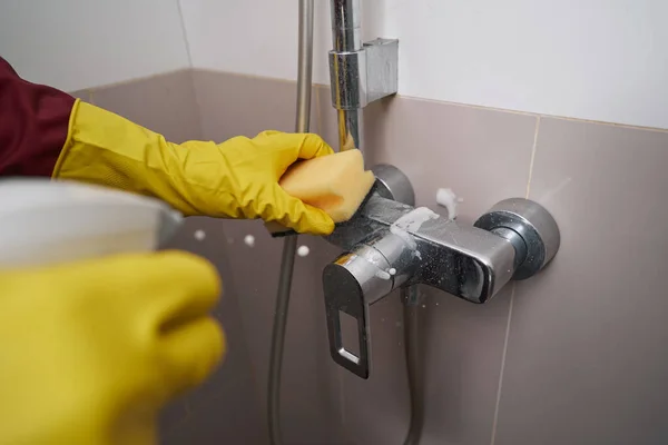 Руки в перчатках, мытье хромированного крана в ванной комнате — стоковое фото