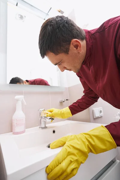 Werknemer in rubberen handschoenen schoonmaken waterkraan — Stockfoto