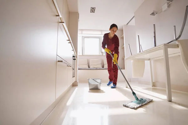 Concentrated uniformed professional janitor doing wet cleaning — Stock Photo, Image
