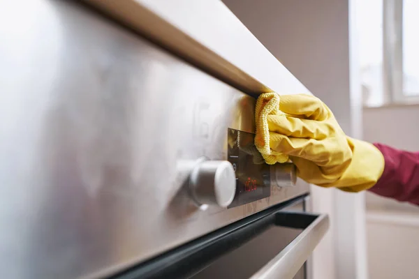 Ervaren conciërge die keukenapparatuur schoonmaakt — Stockfoto