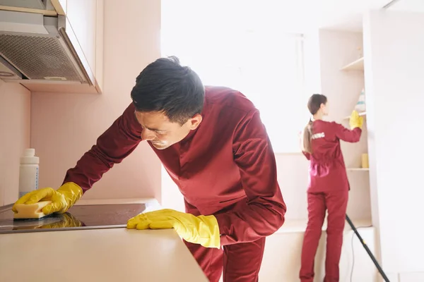 Профессиональный уборщик делает уборку на кухне — стоковое фото