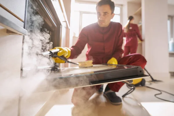 Zwei erfahrene Reinigungskräfte in Uniformen reinigen Küche — Stockfoto