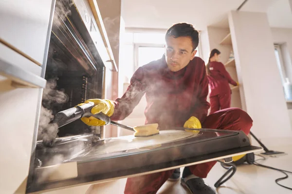 Pessoal de limpeza profissional fazendo limpeza de cozinha eco-friendly — Fotografia de Stock