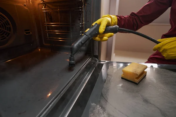 Petugas kebersihan profesional dalam sarung tangan karet membersihkan peralatan dapur — Stok Foto