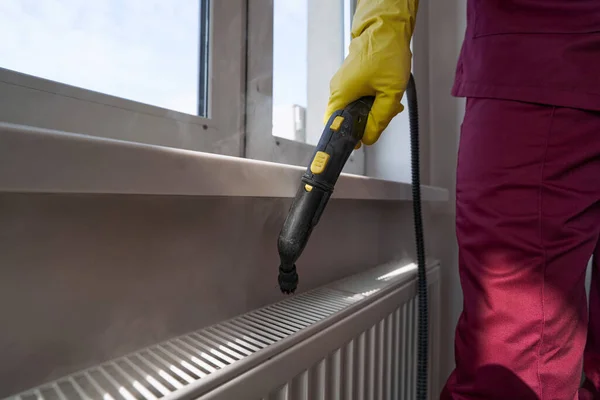 Janitor limpeza aparelho de aquecimento com equipamento de limpeza a vapor — Fotografia de Stock
