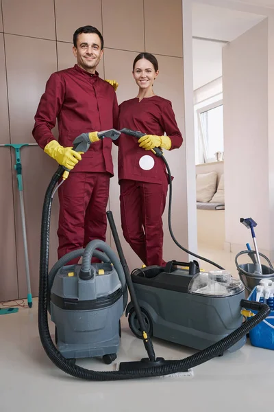 Due lavoratori con attrezzature per la pulizia in posa per la fotocamera — Foto Stock