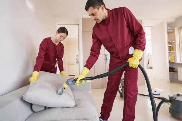 Due operai qualificati in uniforme cuscino divano pulizia a vapore — Foto Stock