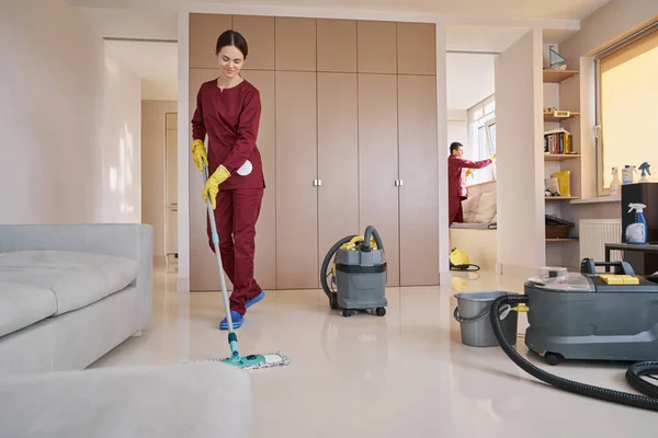 Dos uniformados limpiadores caucásicos haciendo limpieza de la casa profesional — Foto de Stock