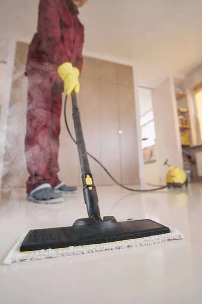 Professional cleaner in rubber gloves using steam-cleaning appliance — Stock Photo, Image