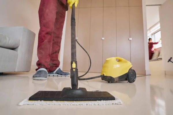 Housecleaner in rubberen handschoenen met stoomreinigingsapparatuur — Stockfoto