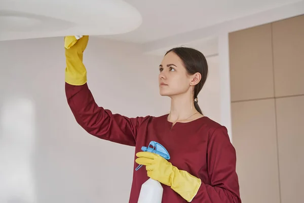 Εστιασμένη housecleaner σε ελαστικά γάντια καθαρισμού οροφής — Φωτογραφία Αρχείου