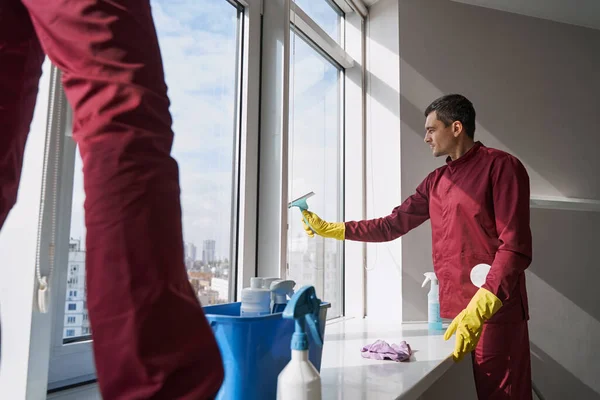 Geüniformeerde professionele conciërge die groot raam wast — Stockfoto